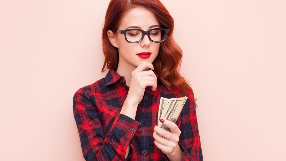 お金を持って考えてる女性