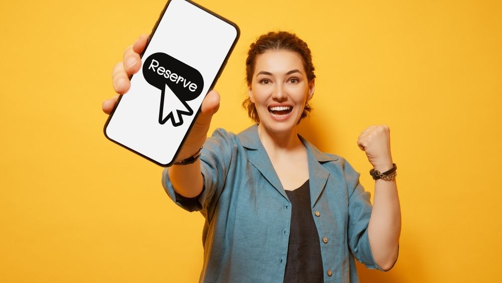 スマホで予約が取れて喜ぶ女性