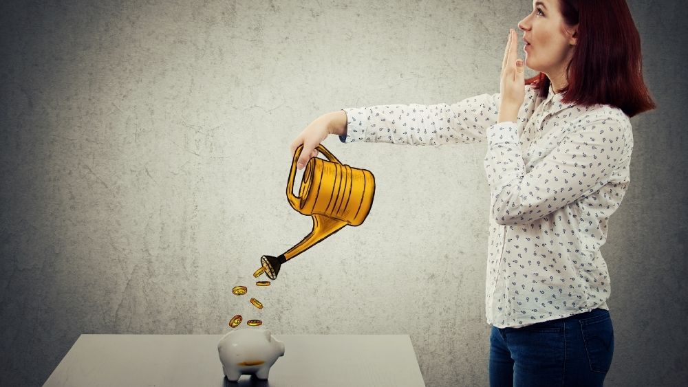 ジョウロから出ているお金を豚の貯金箱に入れてる女性