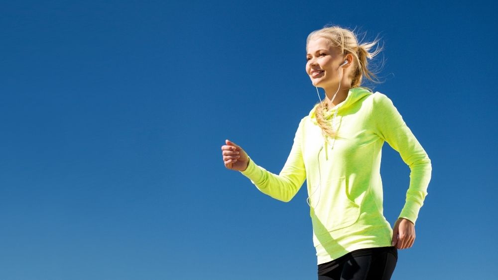 青空の下でウォーキングをしている女性