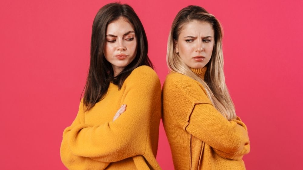 相性が悪く、背中合わせで不機嫌になっている2人の女性
